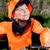 Child wearing an orange reflective bug coat with mesh hoodon a bike outdoors